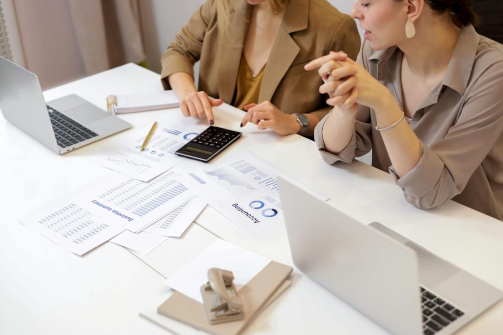 Deux professionnels collaborant sur des documents financiers dans un bureau moderne.