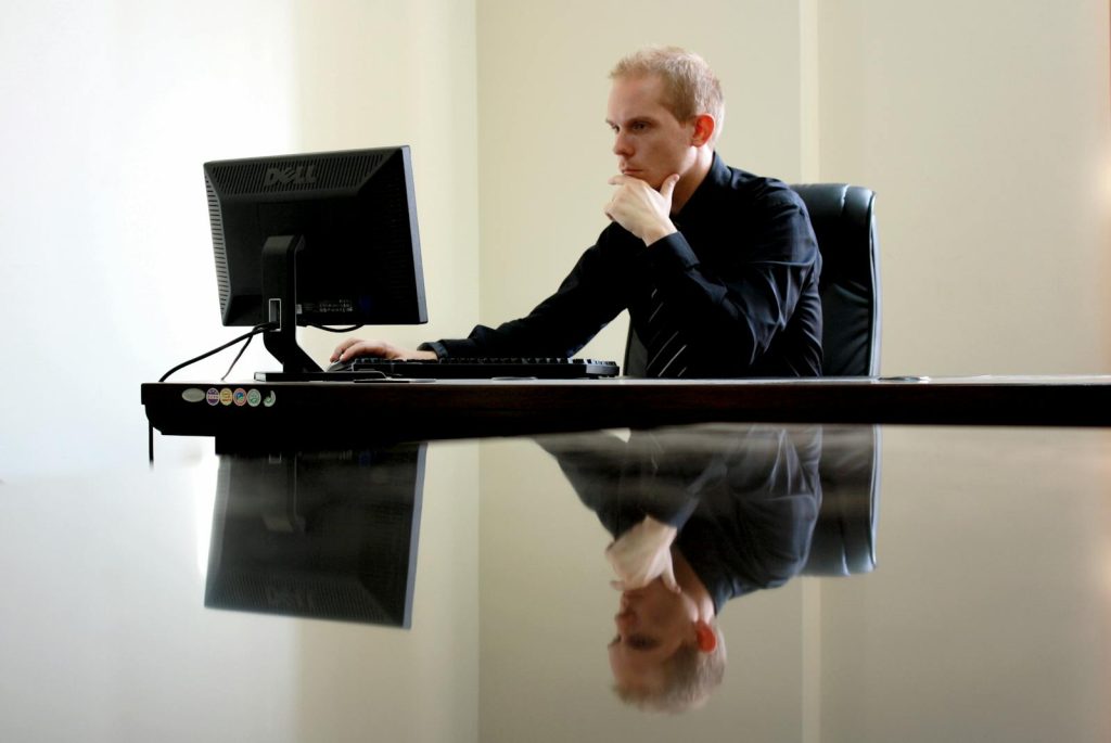 Un homme d'affaires en pleine réflexion à son bureau, réfléchissant à ses tâches.