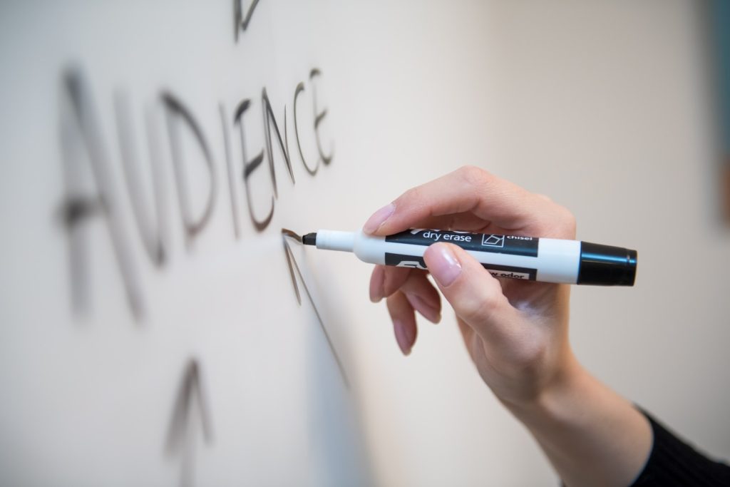 personne tenant un stylo à bille blanc et bleu