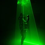 man in black jacket and pants holding green light